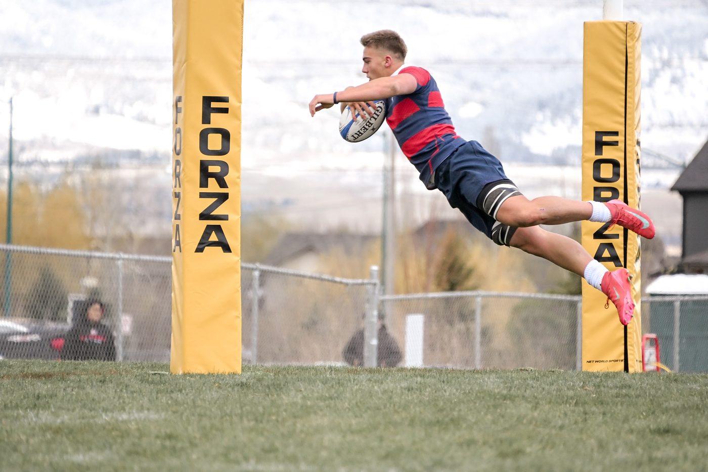 A player dives over to score beside the posts
