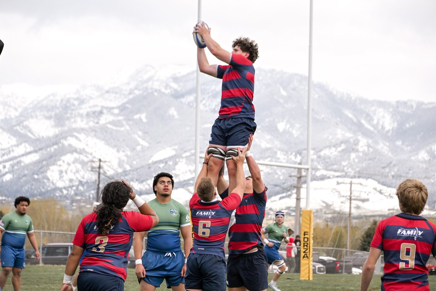 A lineout jumper claims the ball against the mountains