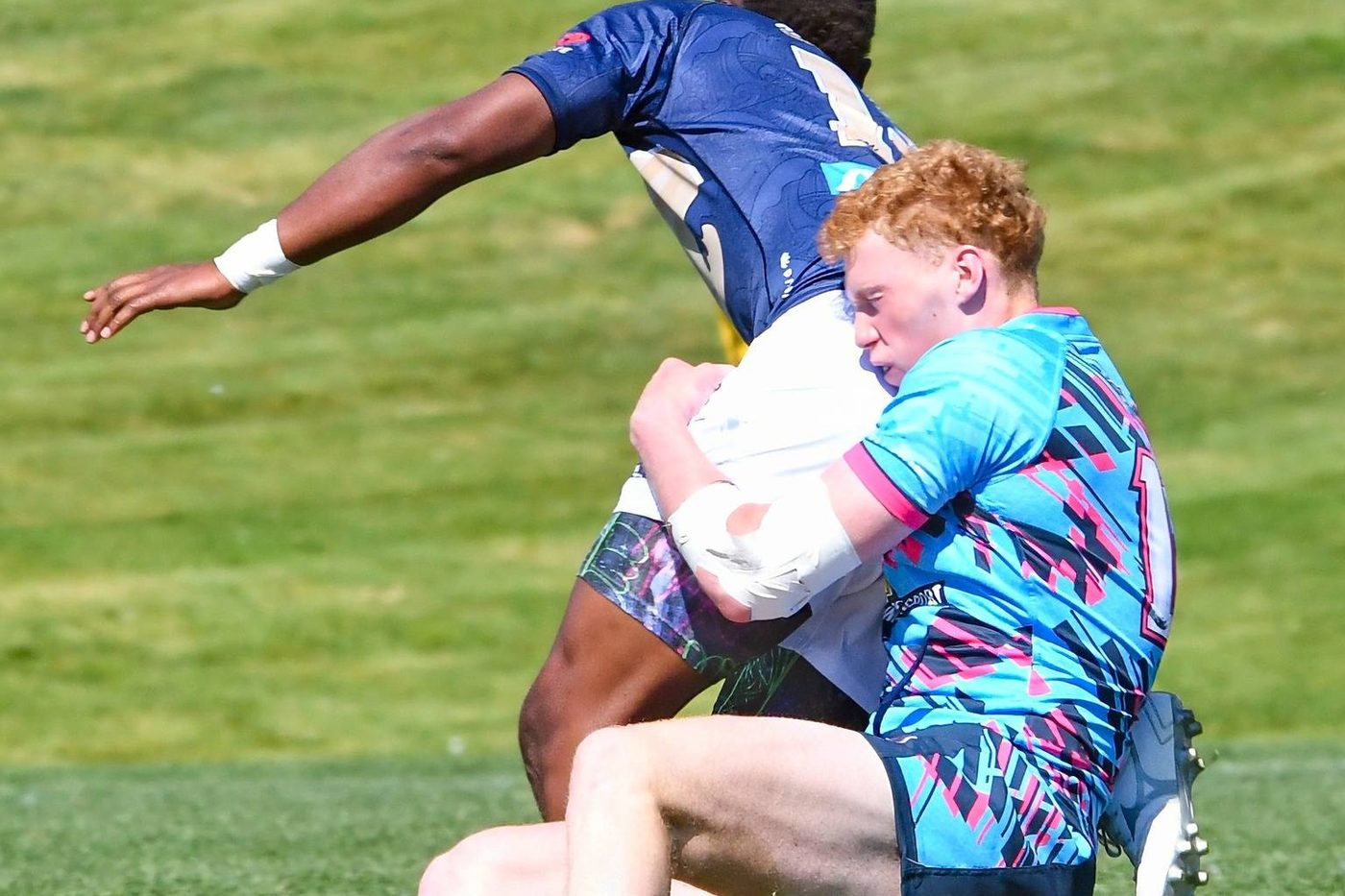 A tackle is completed in the summer sun