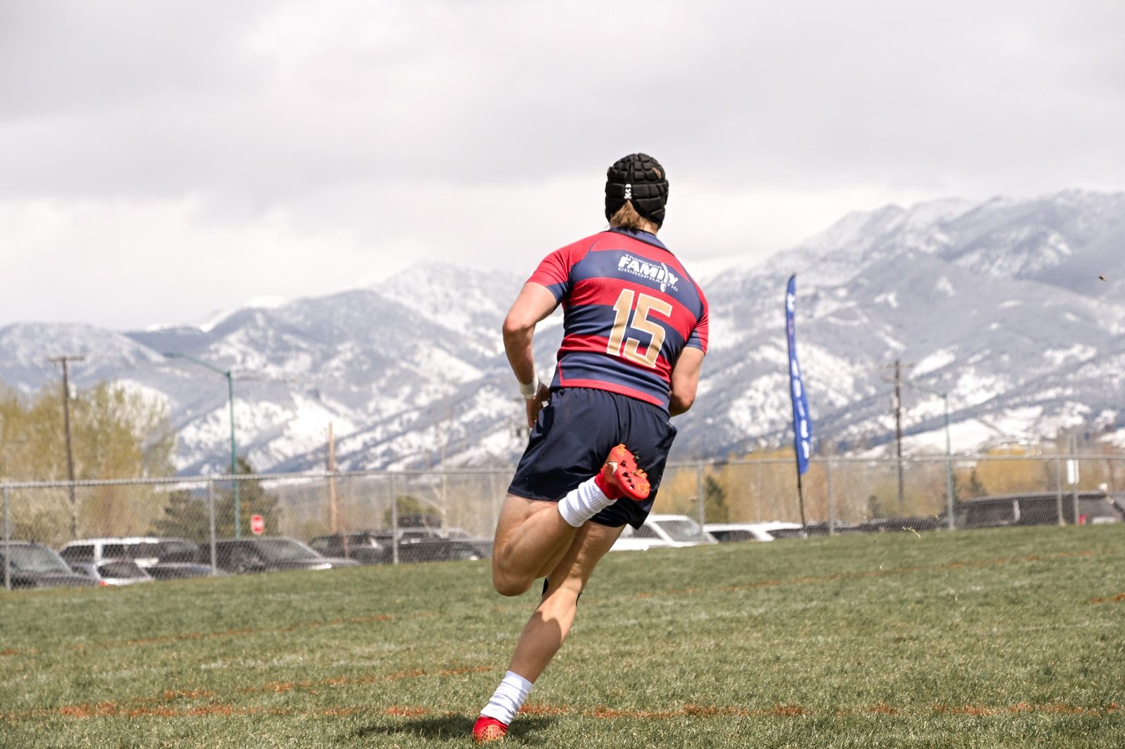 A player runs clear with the mountains around Bozeman behind the pitch