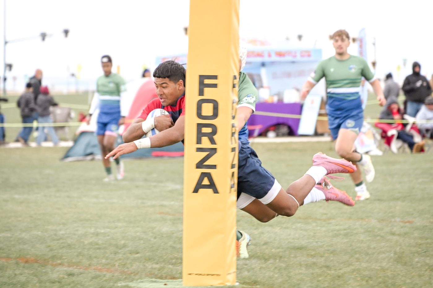 A player dives over to score beside the posts